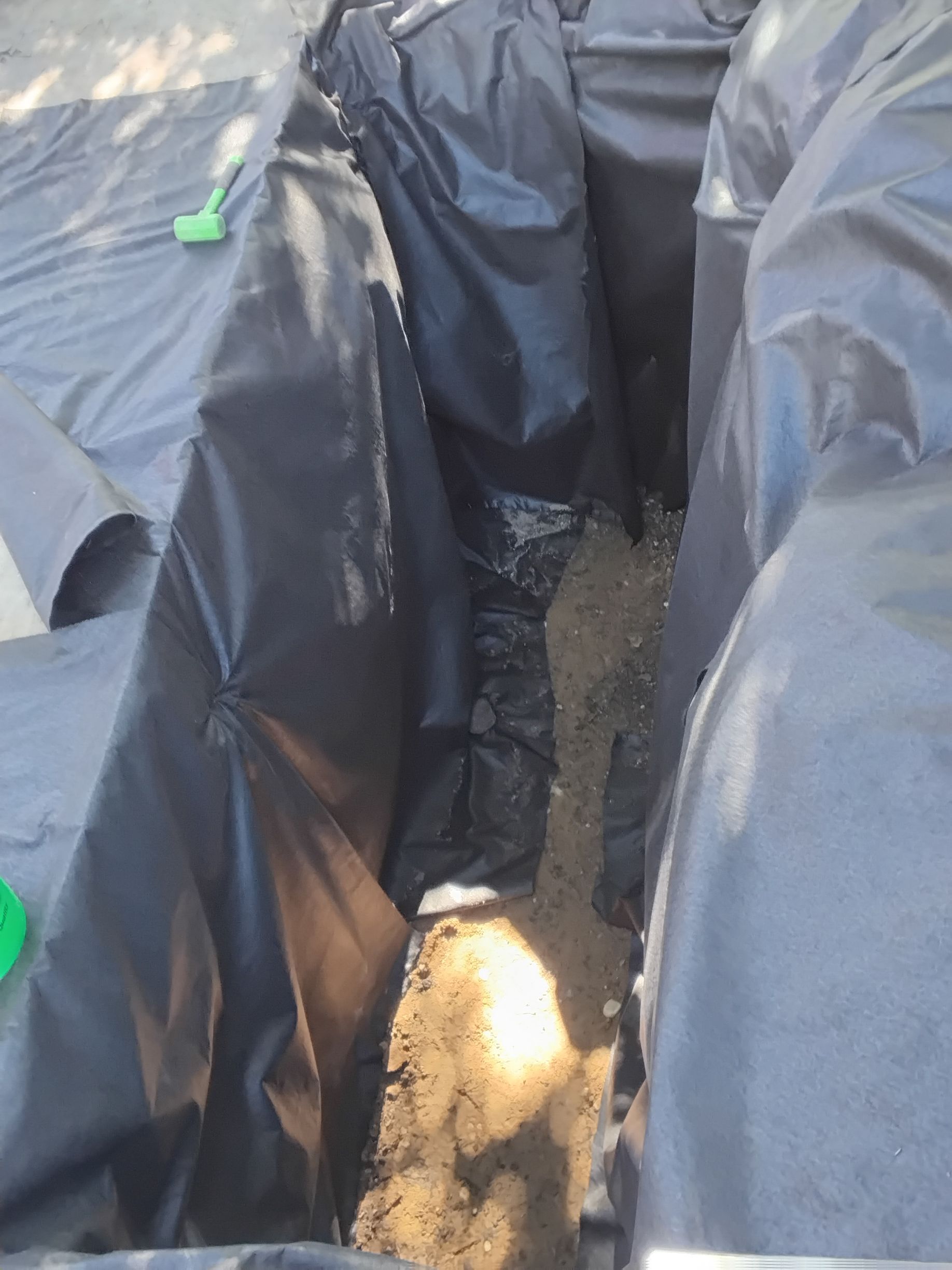 During: lining the dry well pit with thick durable filtration fabric on sides