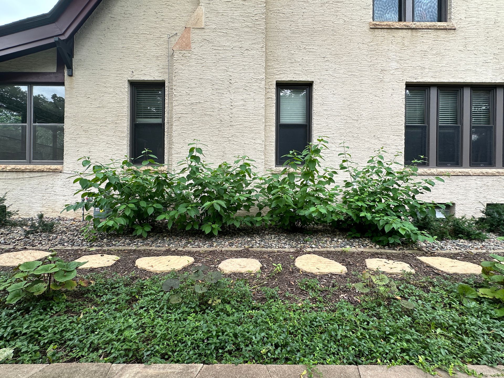 Side yard landscaping replacing steep hill with walking path and stepping stones in Minneapolis by KG Landscape