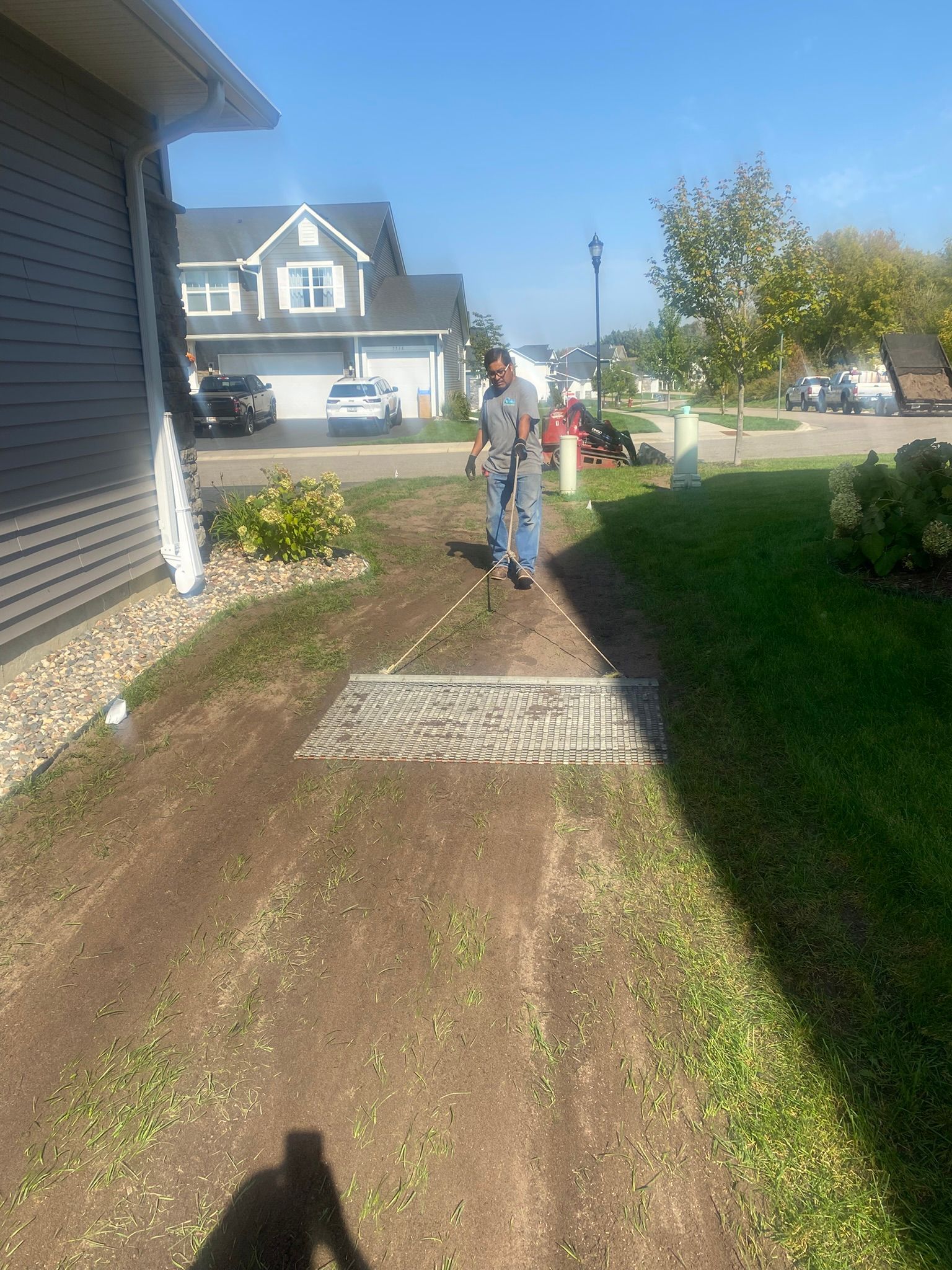 During: foreman smoothing applied soil via lawn drag