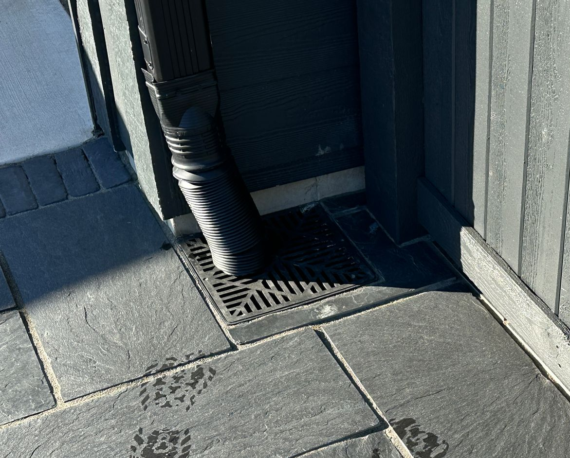 Catch basin with underground drain pipe we installed in Plymouth at the corner of garage to send water below new walkway 