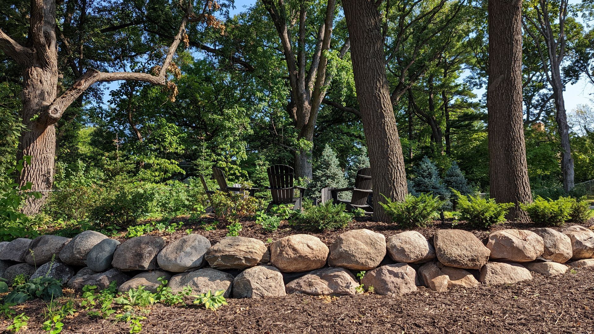 using boulders to create a flat space for a fire pit area on a hill