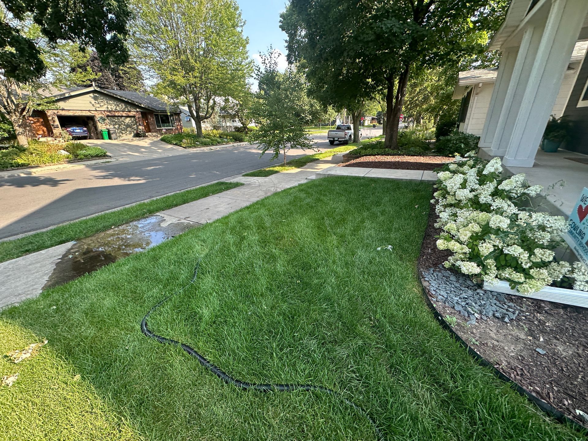 Water issue at home in Minneapolis flexible sump-pump water line extension in lawn dumping onto city sidewalk in front yard
