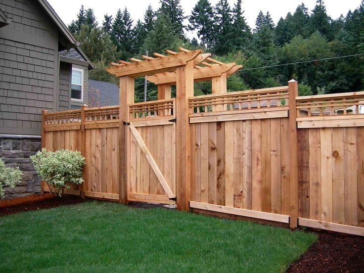 A wooden fence with a pergola attached to it