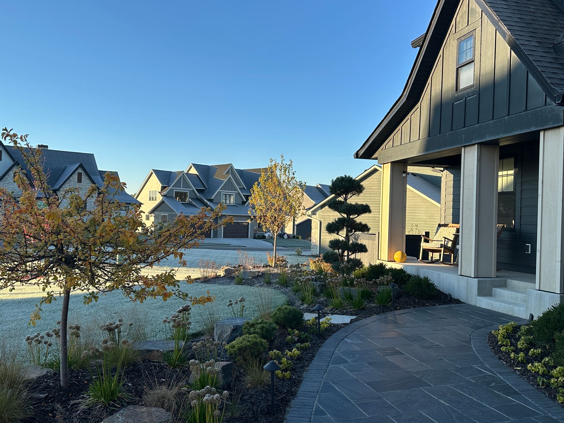 Front yard landscaping with black stone walkway. 