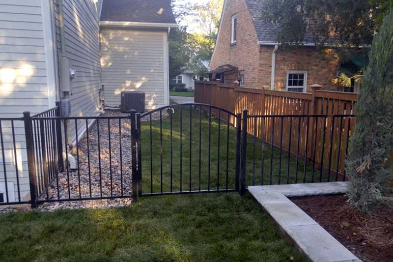 There is a fence in the backyard of a house.