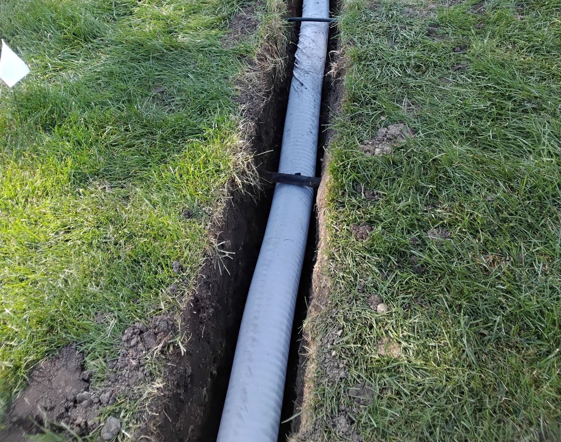 During picture of drain tile being installed to fix a muddy lawn in MN
