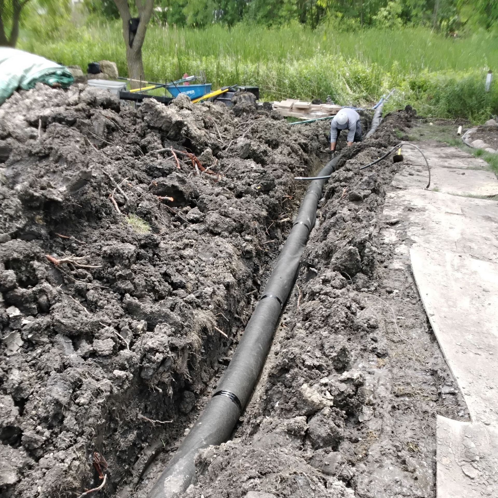 drain tile primary line wrapped with filtration fabric for tree root protection in MN by KG Landscape