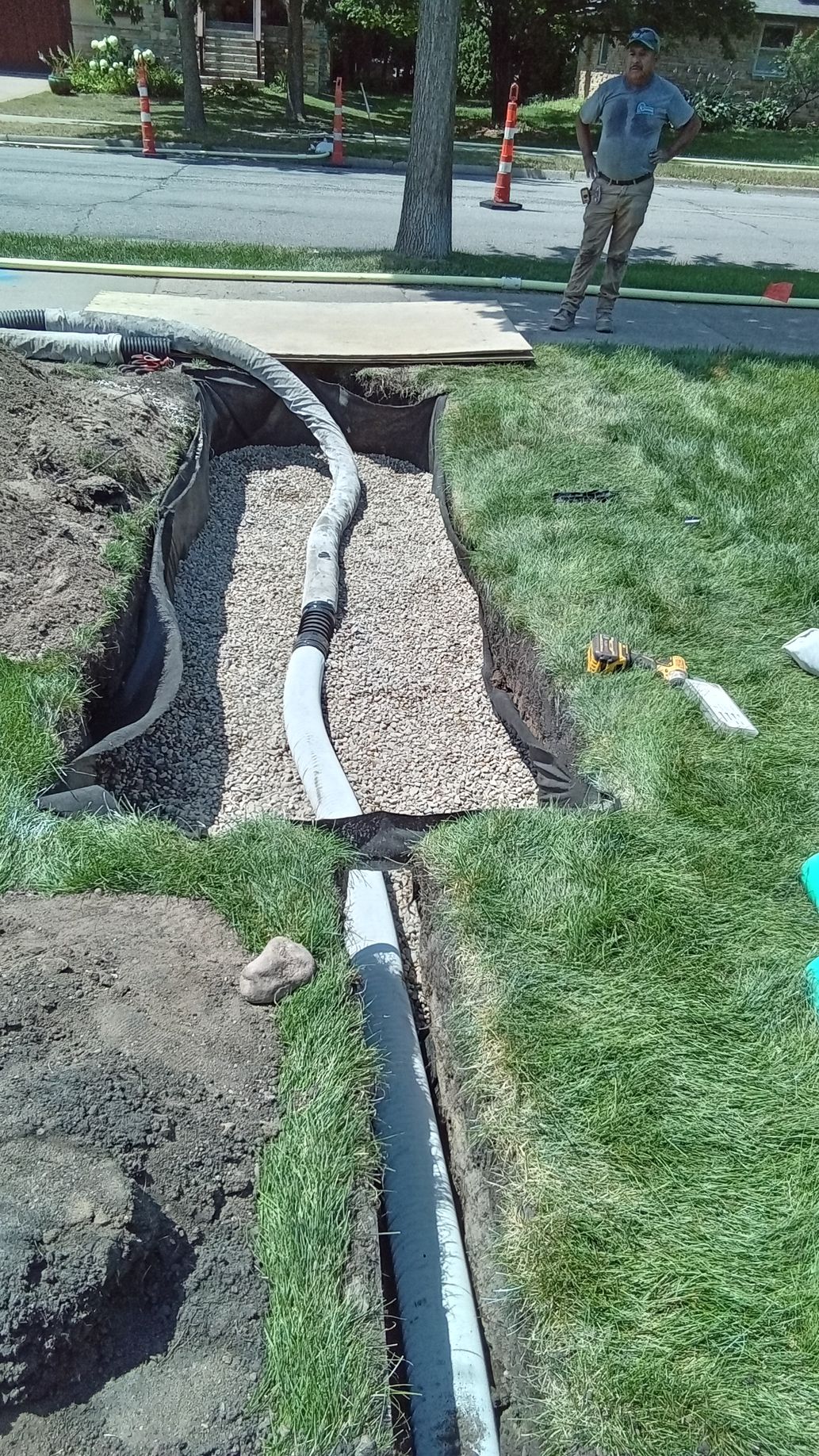 During: shows crew nearing the completing of  dry well with rock fill up to drain pipe entry elevation