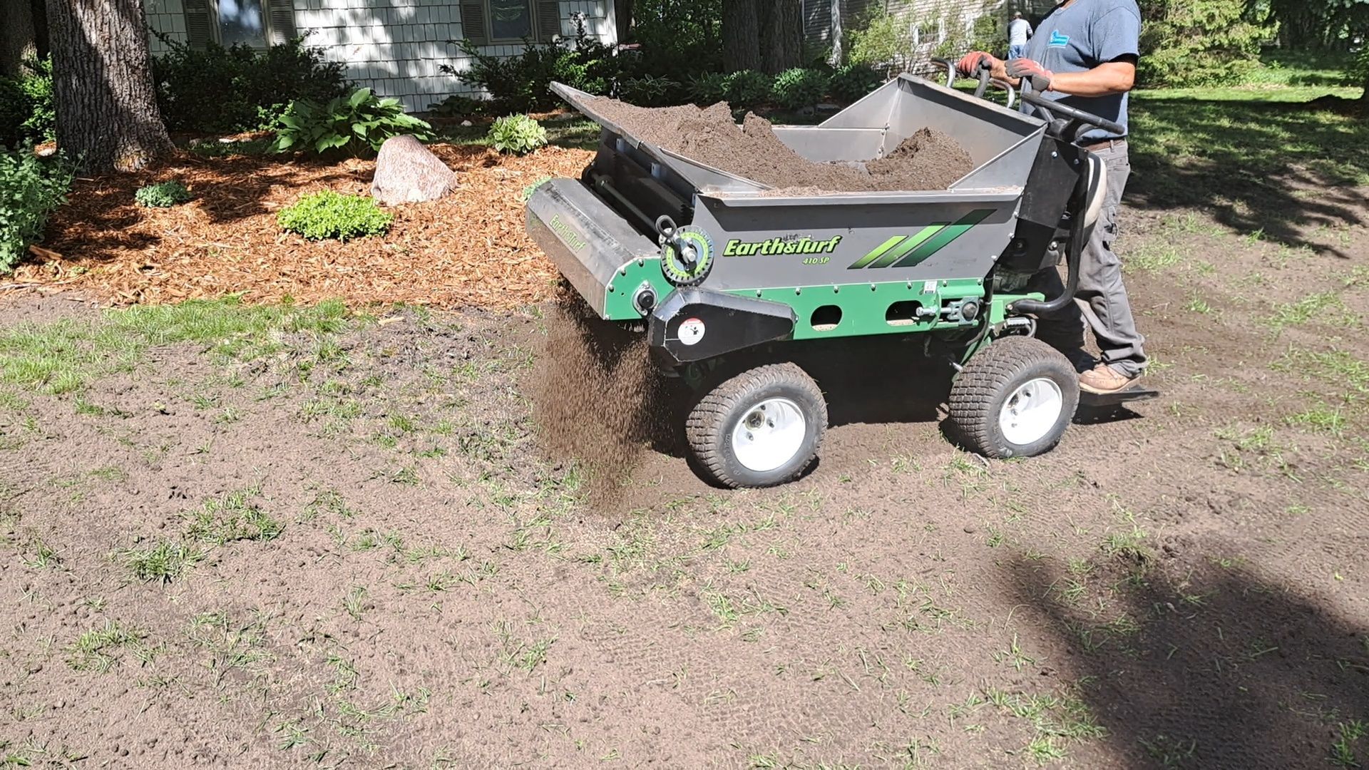 Organic Compost being distributed over lawn.