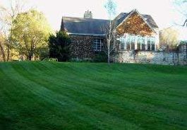 A large house with a lush green lawn in front of it.