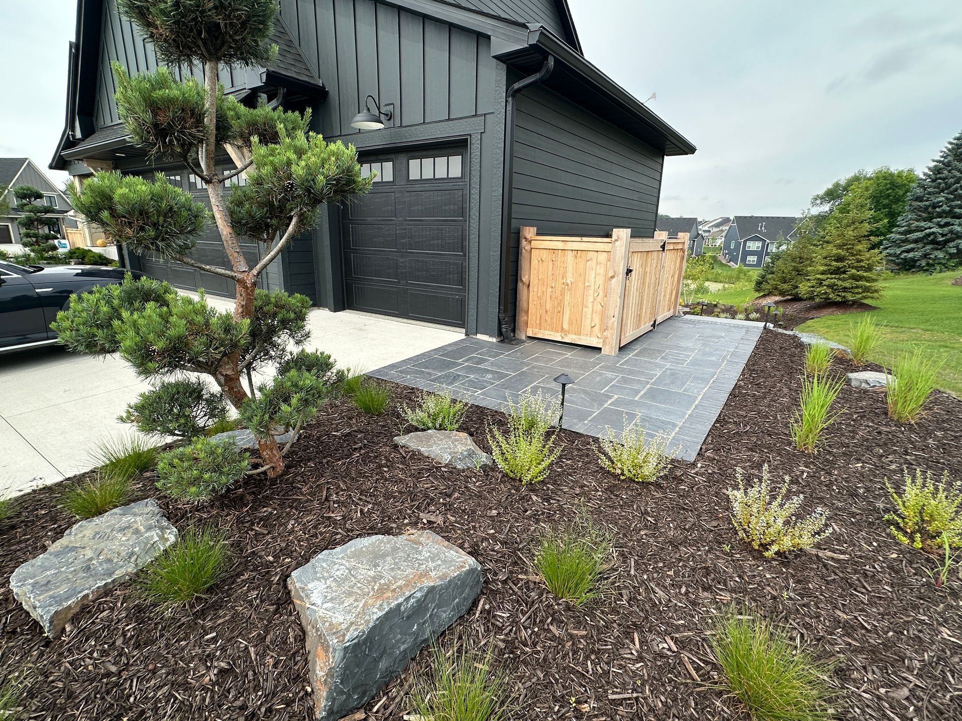 Garbage can pad and with walkway using pavers with cedar fence and gate to block view of waist bins KG Landscape MN 