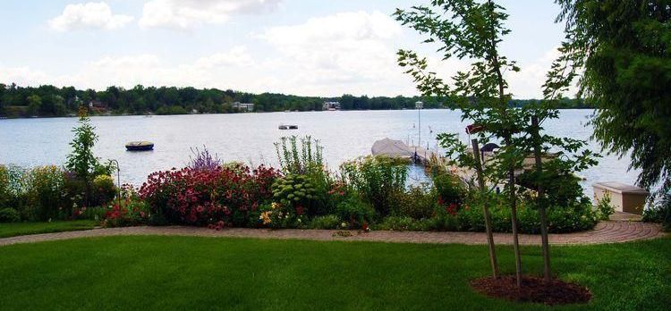 A view of a lake with a dock and trees in the foreground