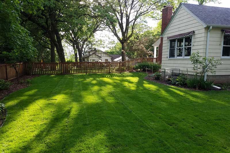 A house with a large lawn in front of it.