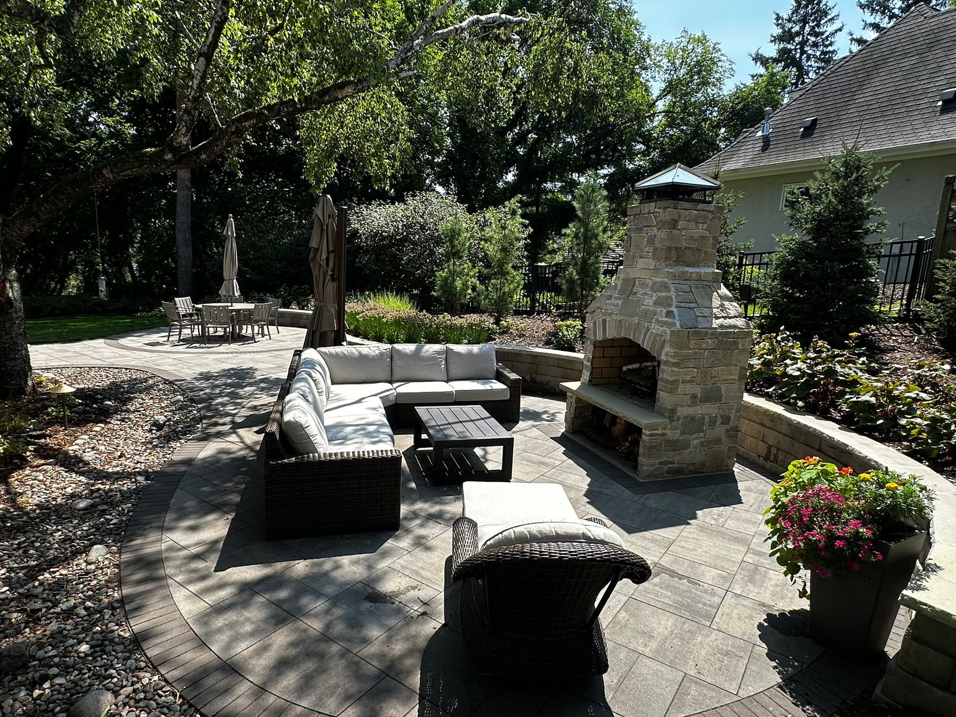 After: our principle designer Kent Gliadon created this amazing new backyard patio space with fire place, privacy plantings and more in Minnetonka MN 