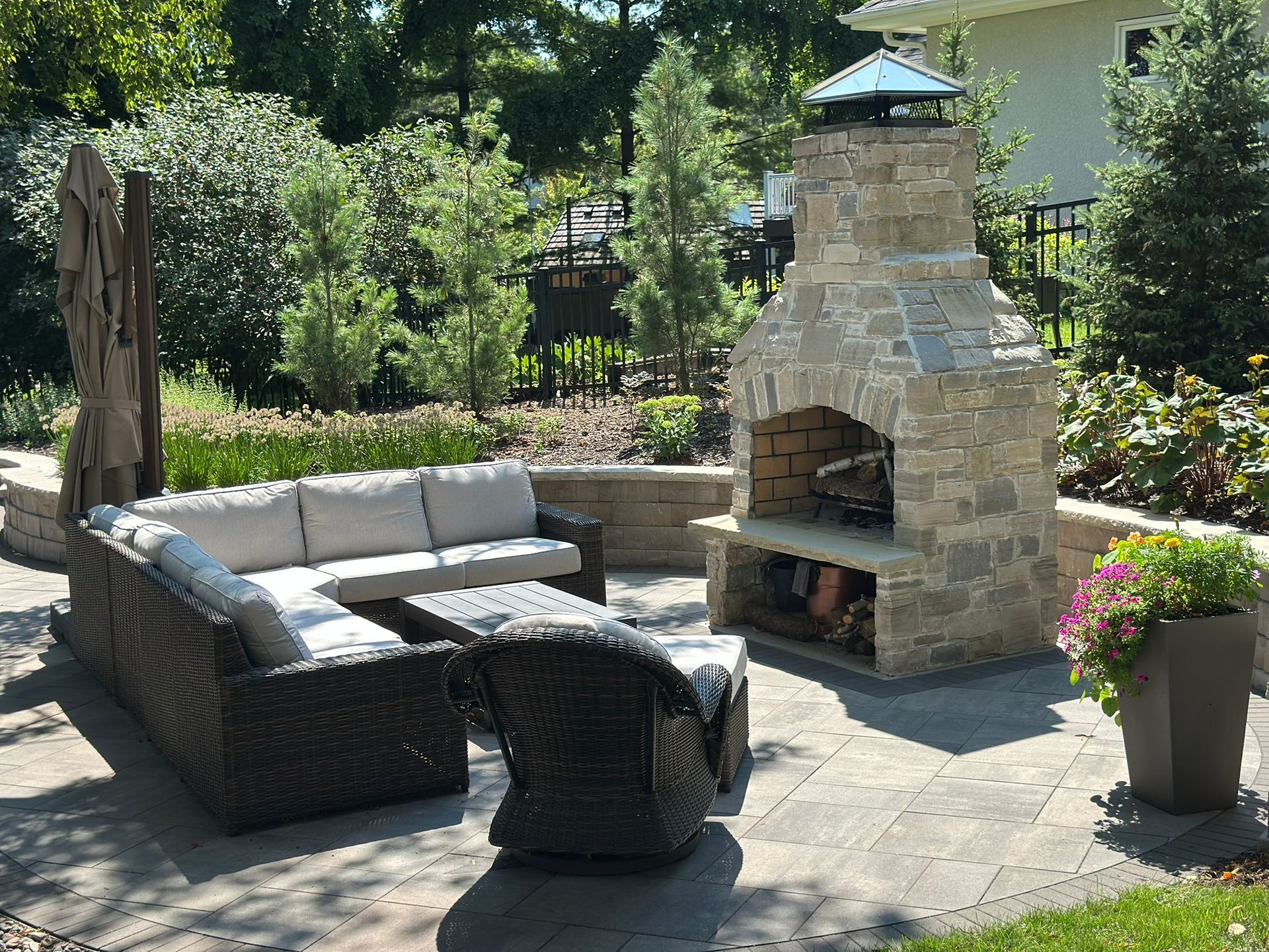 Backyard with patio and fireplace fire feature, landscaping, sitting wall and colorful garden St. Louis park 
