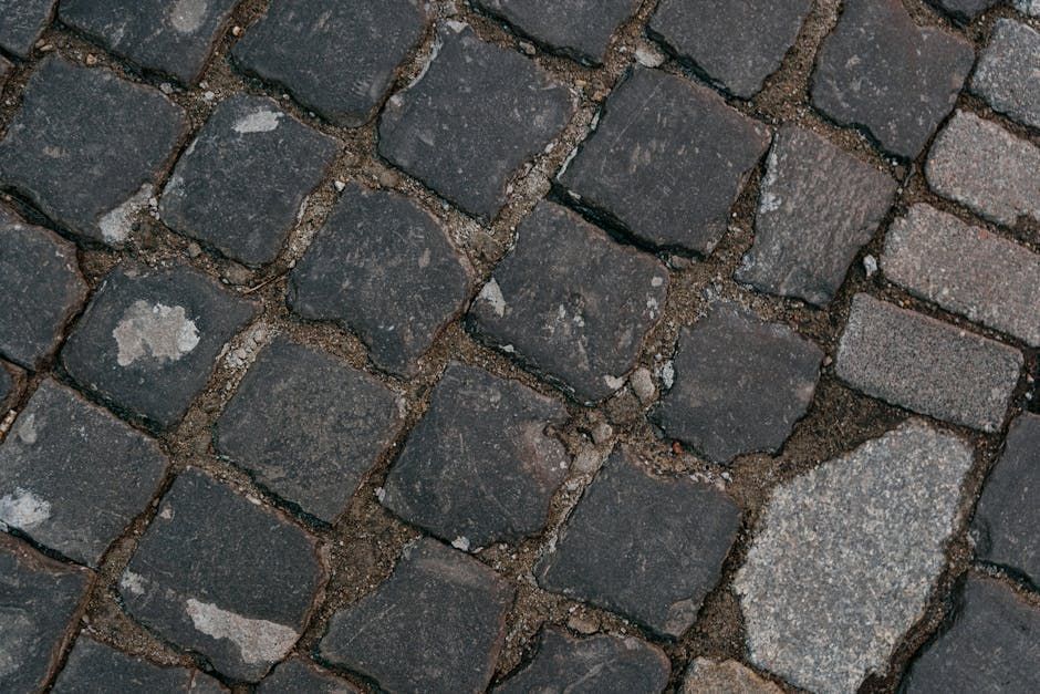 A close up of a cobblestone road with a few stones missing