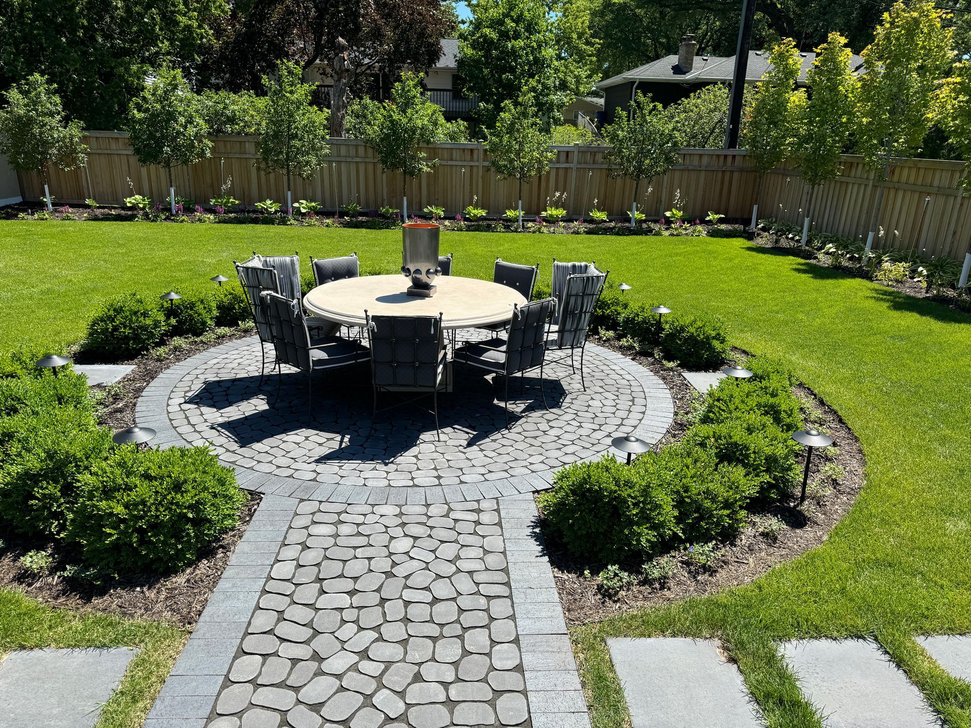 gorgeous backyard landscaping designer KG landscape outdoor living space Edina MN  inspiration ideas tree for privacy cedar fence plantings table chairs stepping stones modern colorful 