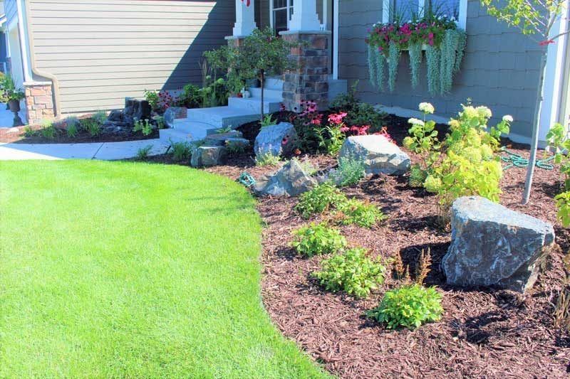 Front yard boulder outcropping landscaping with flowers colorful in Chanhassen MN colorful with interest all season long redbud tree KG Landscape.com  