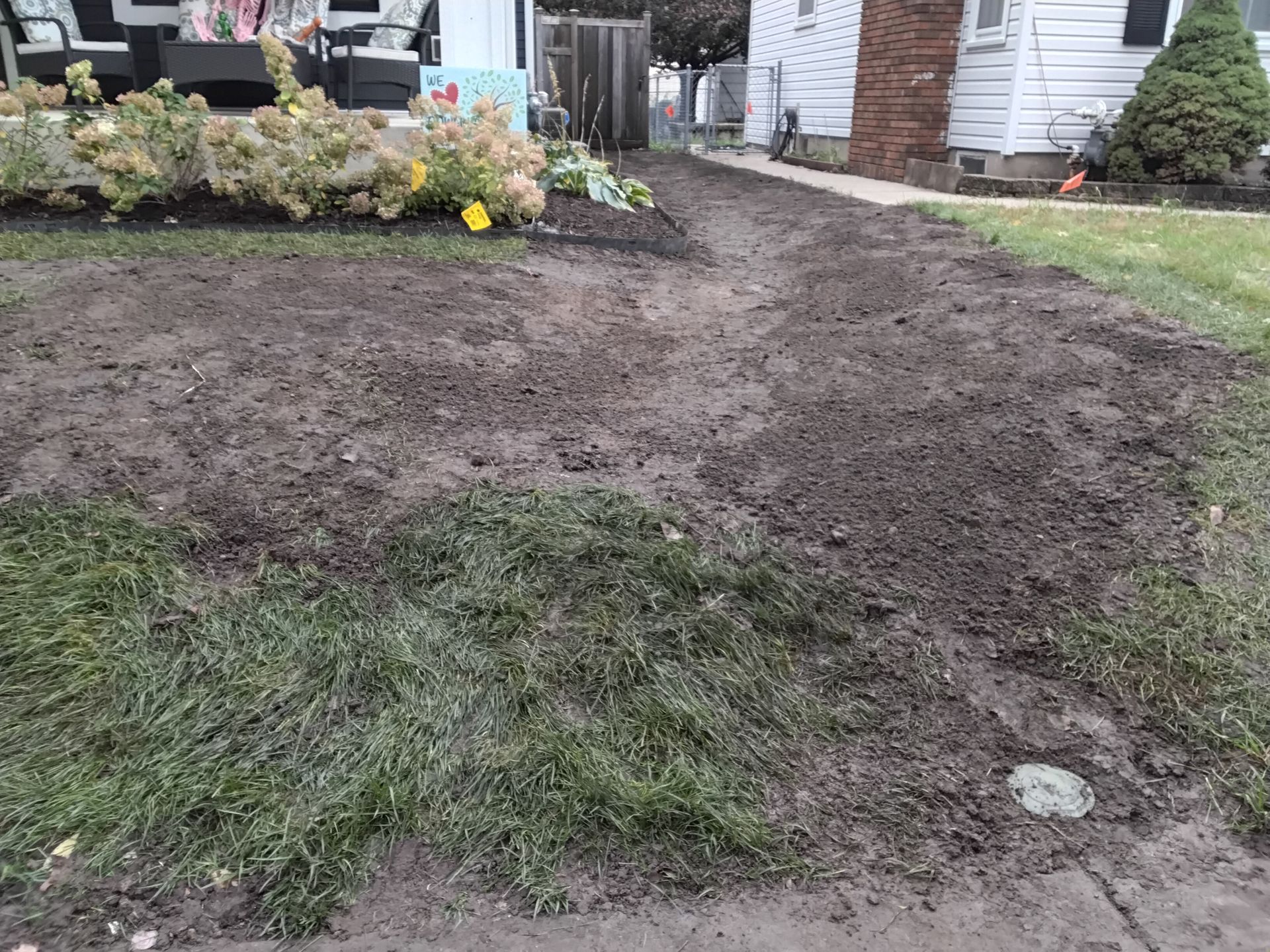 subtle side yard swale sending water away from house and out toward street in front