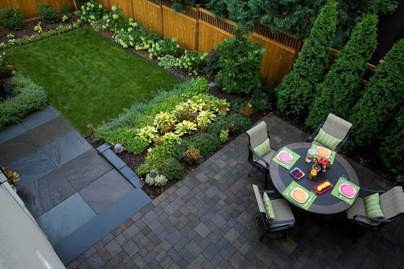 An aerial view of a patio with a table and chairs in a backyard.