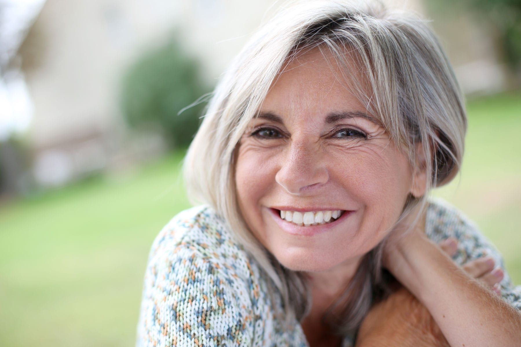 A woman with gray hair is smiling for the camera.