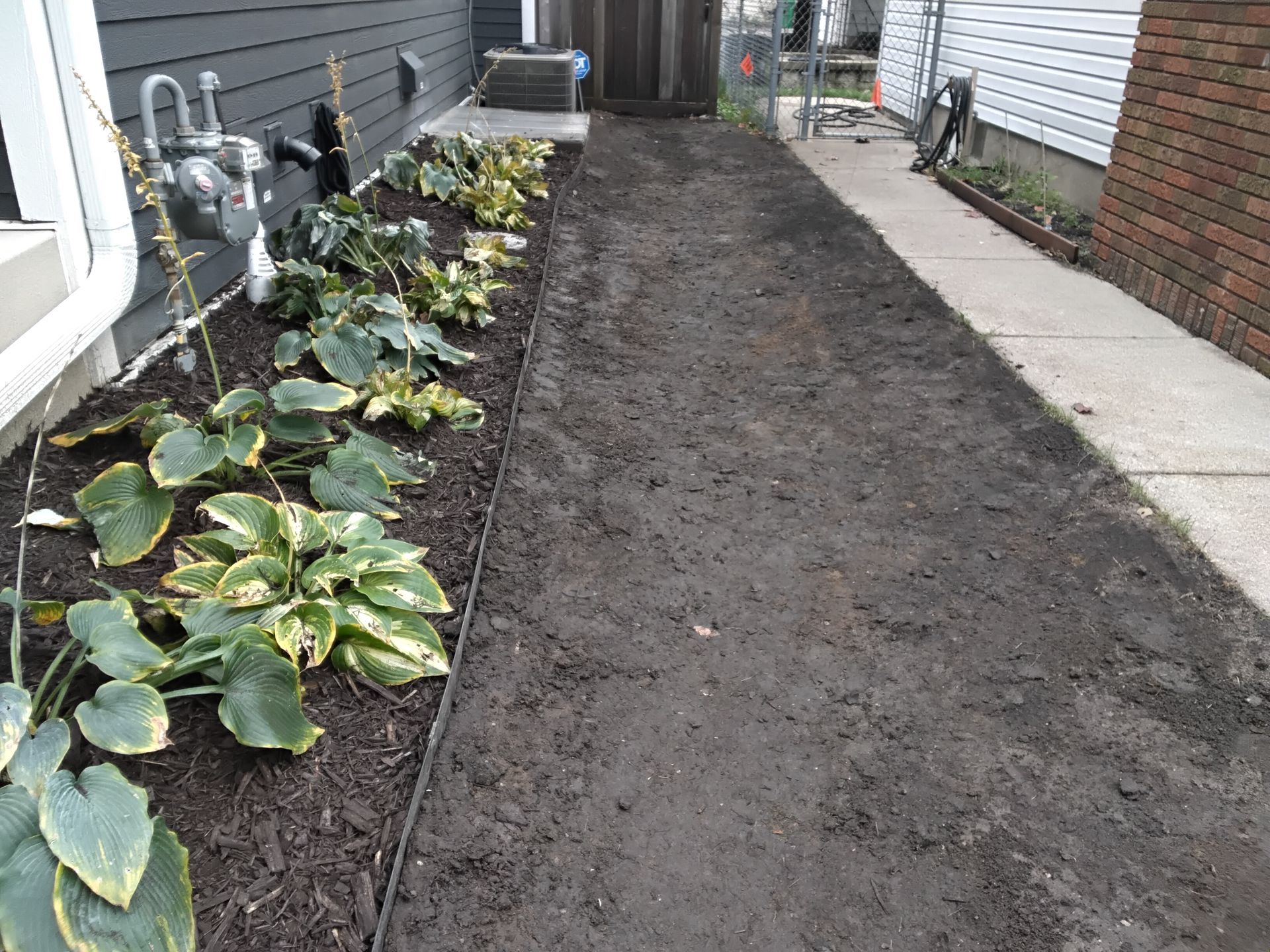 graded side yard drainage swale during crew work 