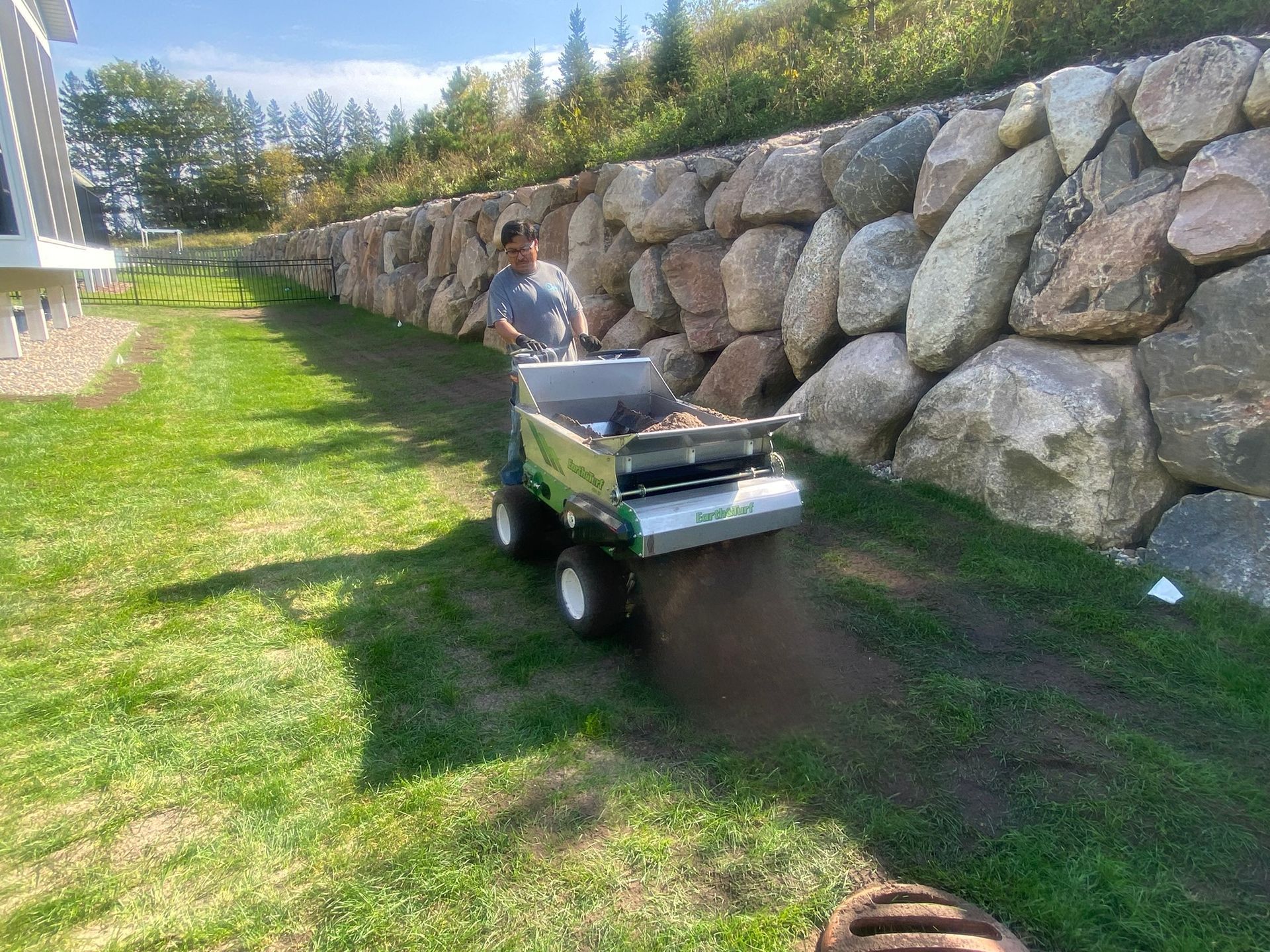 crew member applying topdressing soil to smooth out a bump lawn in MN 