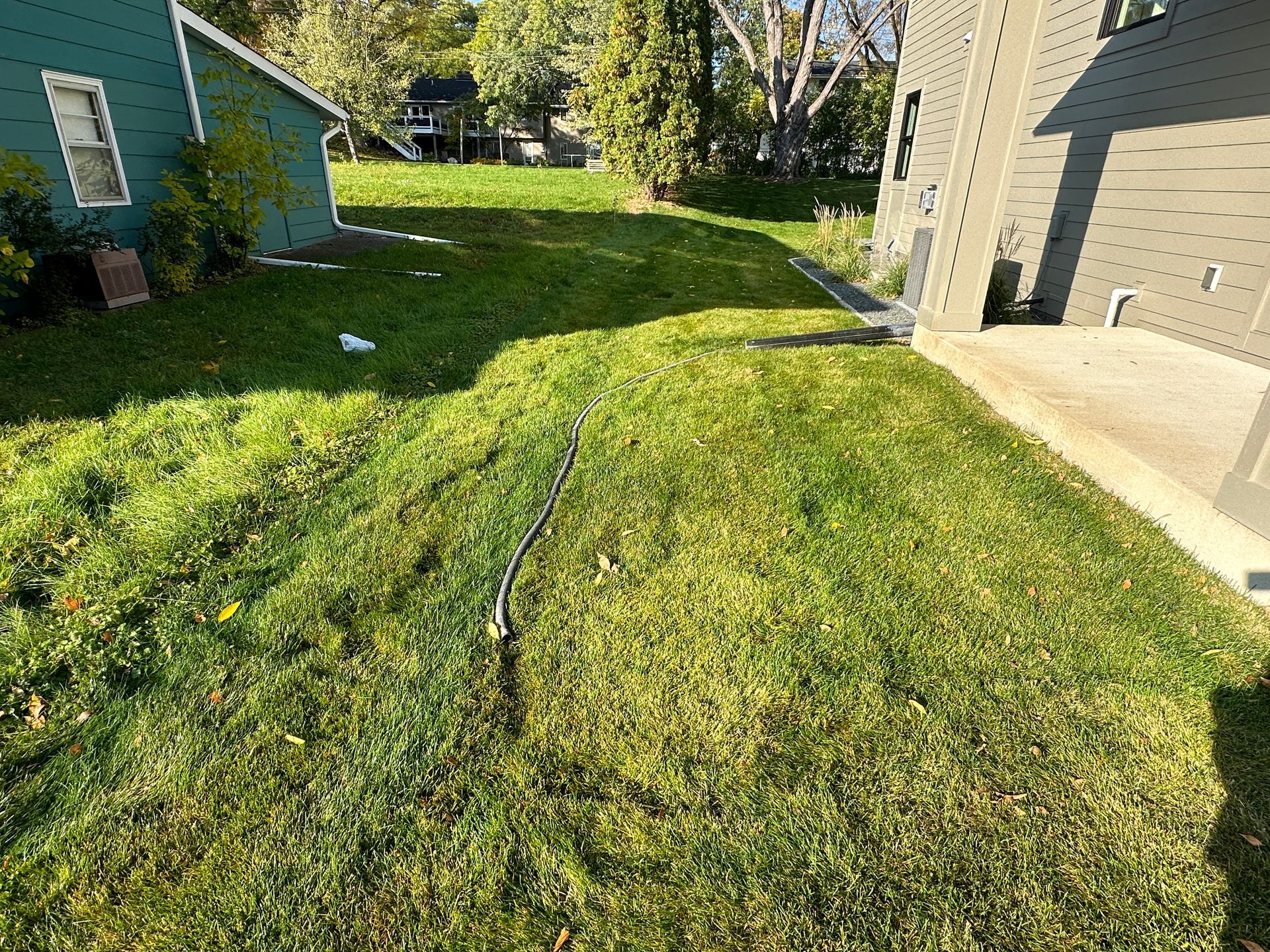 Mushy wet side yard lawn too wet to mow with sump pipe laying in the grass