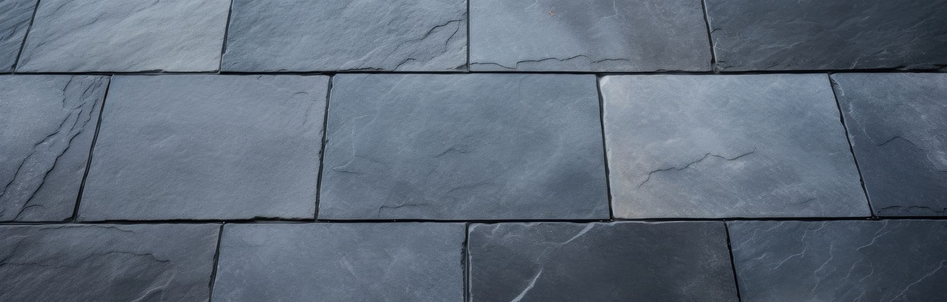 A close up of a row of black tiles on a roof.