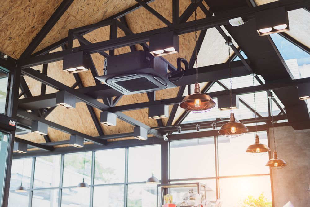 A Large Warehouse With A Lot Of Shelves And A Ceiling Fan — Bay To Bush Electrical In Eli Waters, QLD