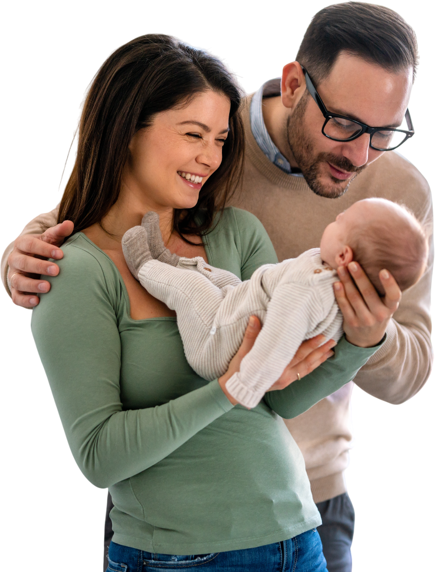 A man and a woman are holding a baby in their arms.
