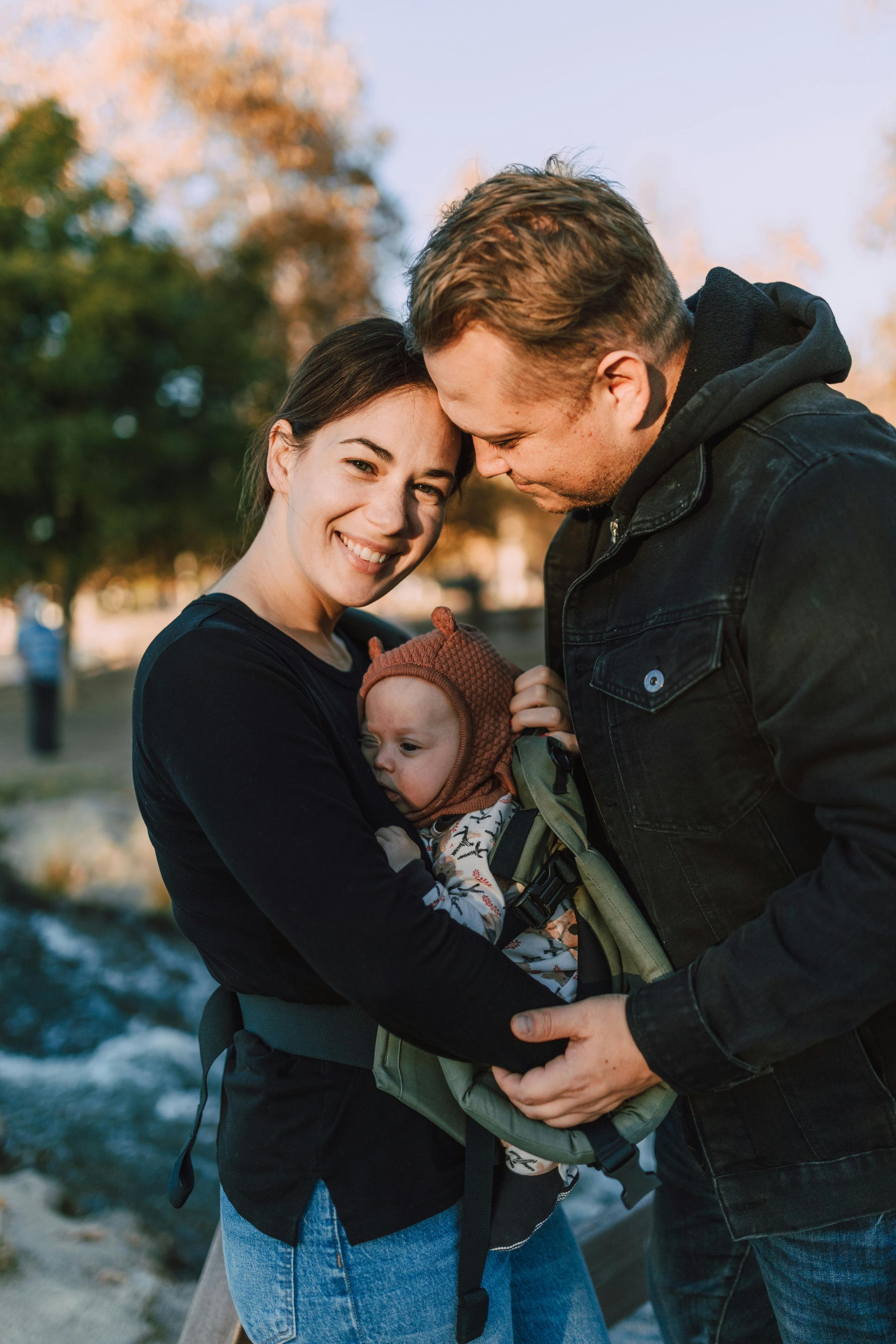A man and woman are holding a little girl in their arms.