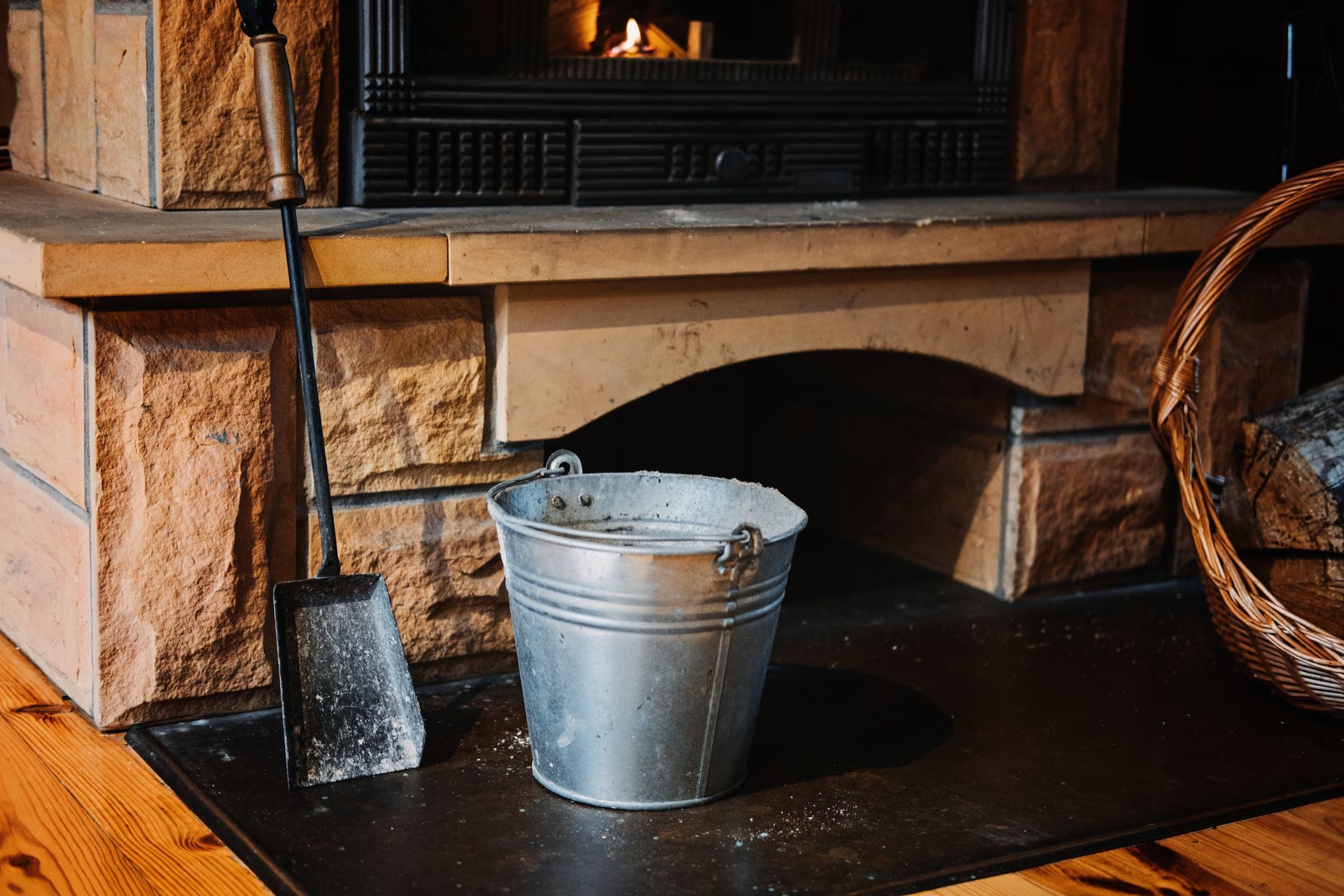 A lit fireplace with brick surround, flanked by speakers and a potted plant, and a TV above.