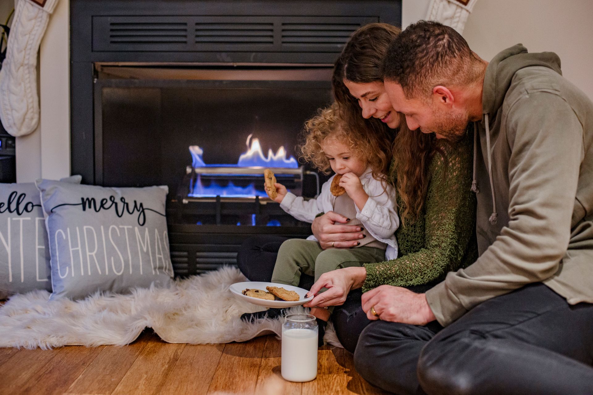 Man installing a fireplace inside a wood-framed structure, interior setting.