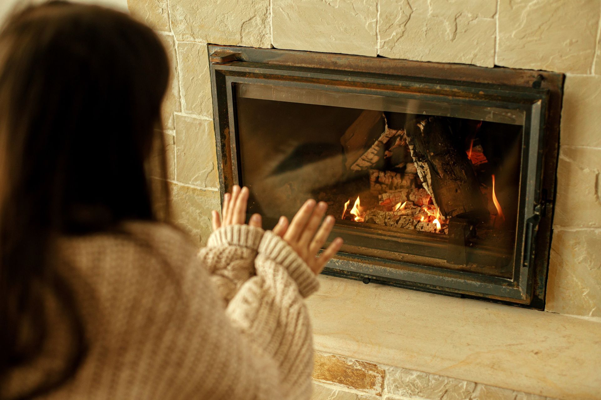 Gas fireplace with burning flames, surrounded by dark green marble.