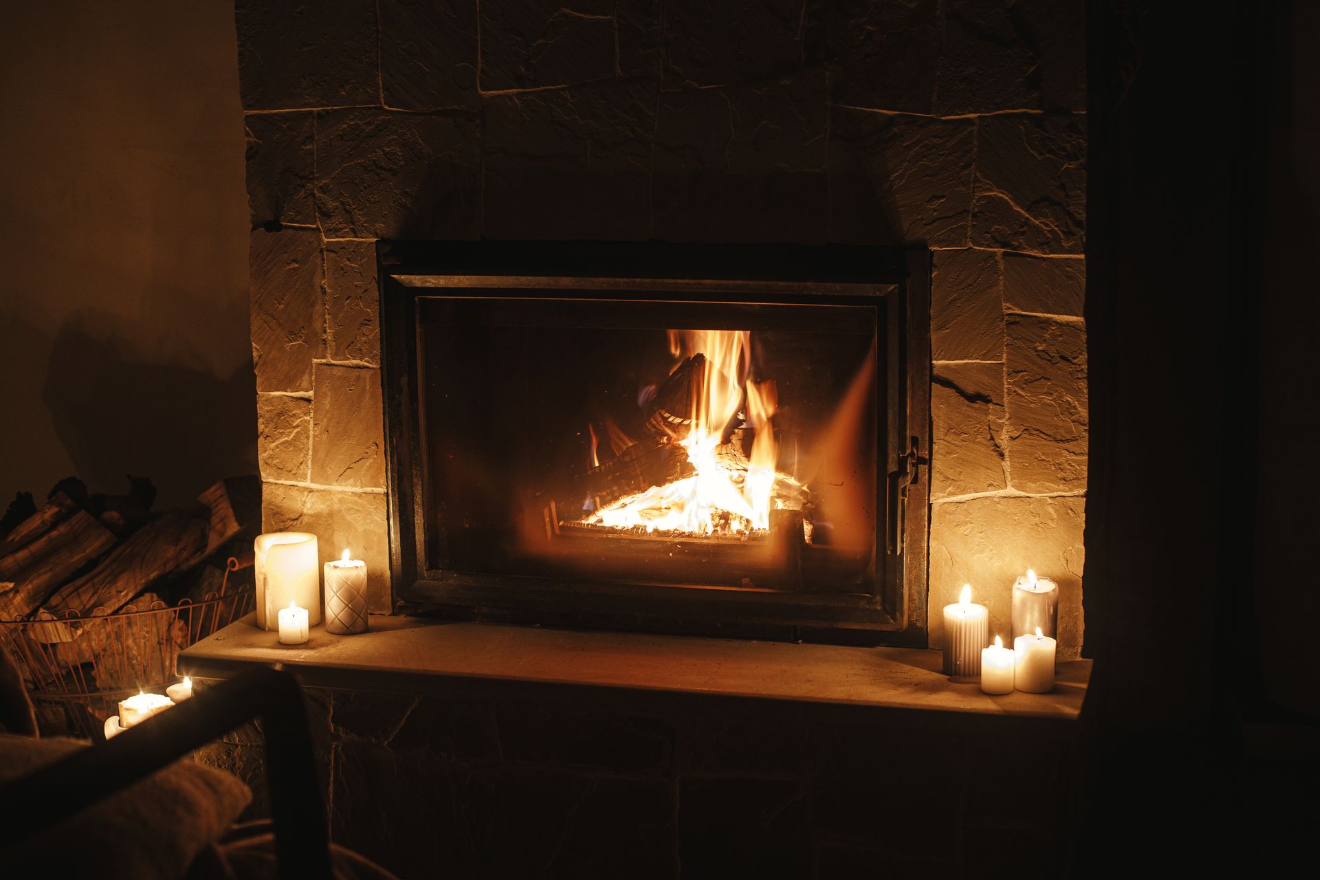 A modern fireplace with flames burning, in a white cabinet below a television.
