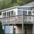 A house with a large deck and lots of windows.