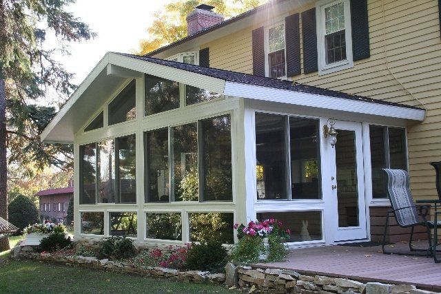 A house with a screened in porch on the side of it