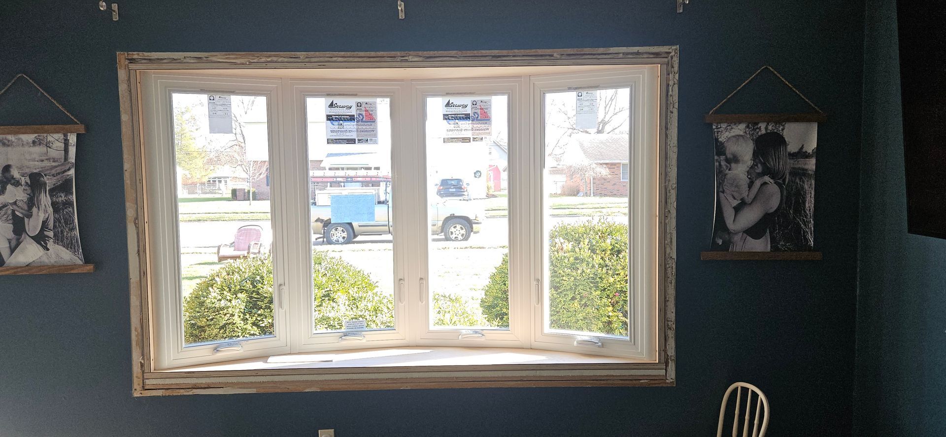 A room with a large window and pictures on the wall.