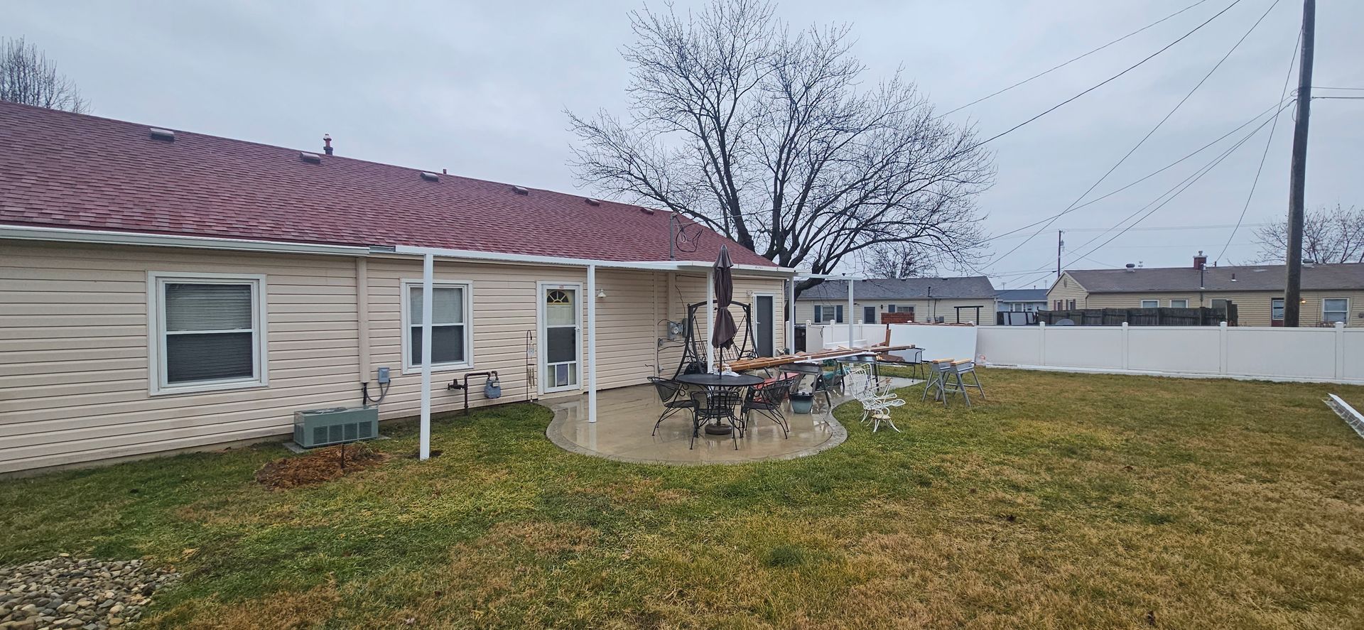 A house with a red roof and a patio in front of it.
