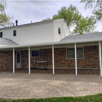 A brick house with a white covered porch