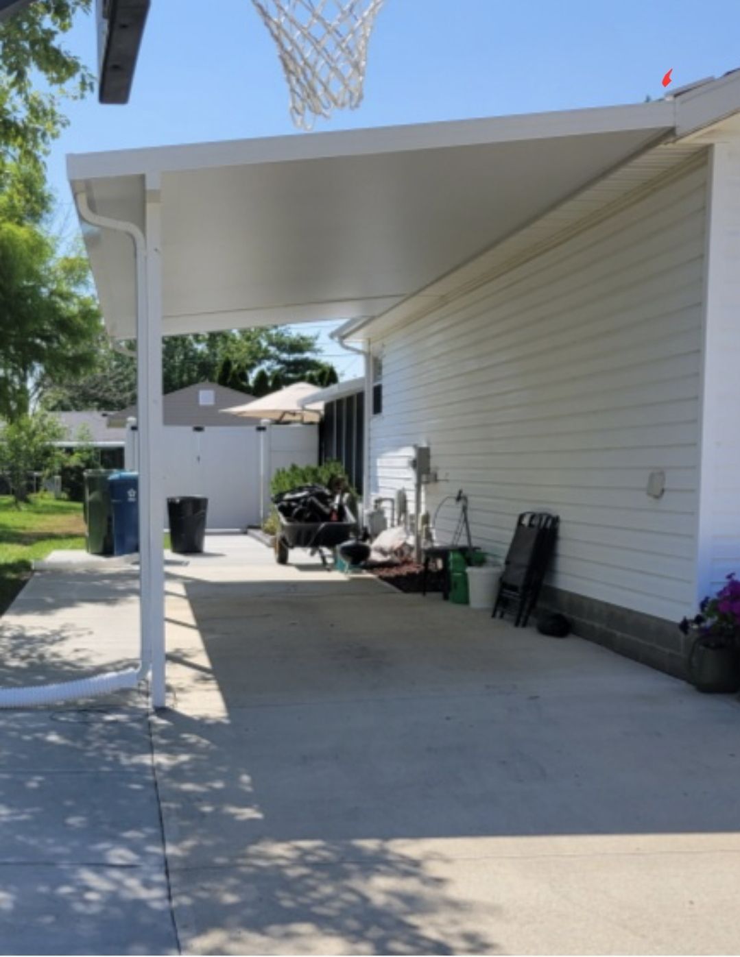 A white carport with a basketball hoop in the background