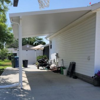 A white house with a basketball hoop in the background