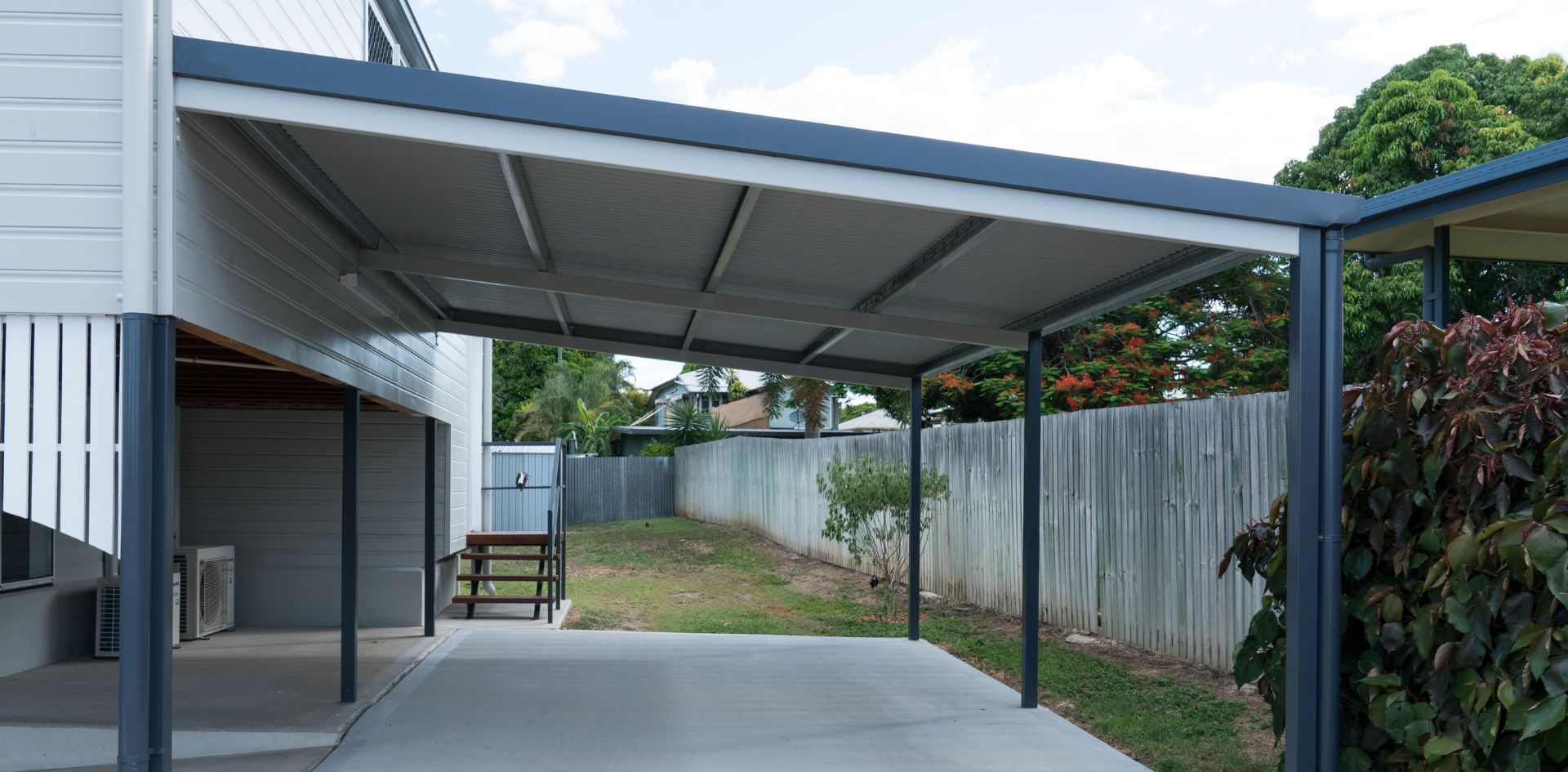 There is a carport in the backyard of a house.