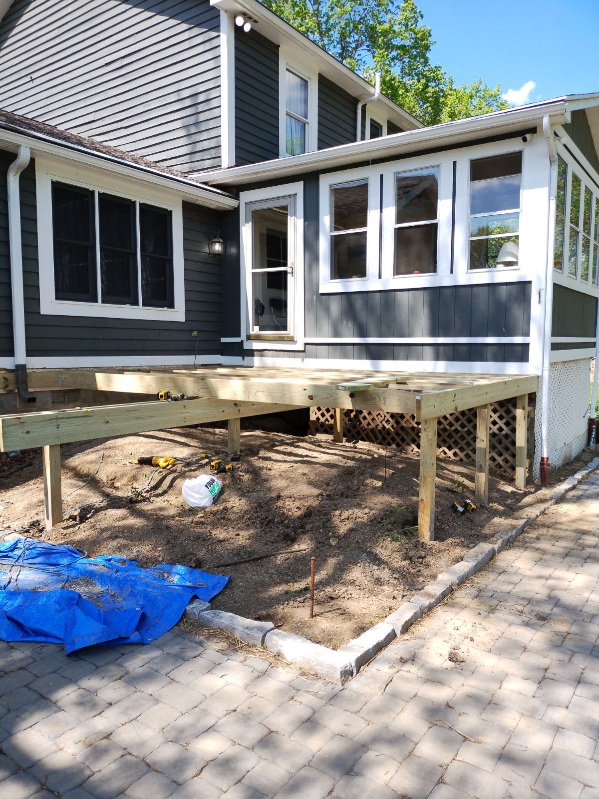 A house with a wooden deck in front of it.