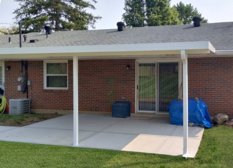 A brick house with a covered patio and a sliding glass door