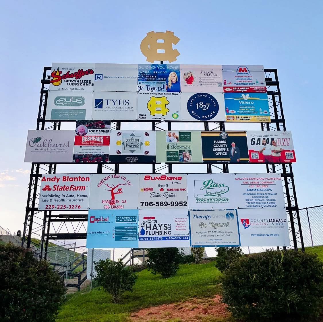 Sign at a sports field with advertising panels and a UNC Tar Heels logo at the top.