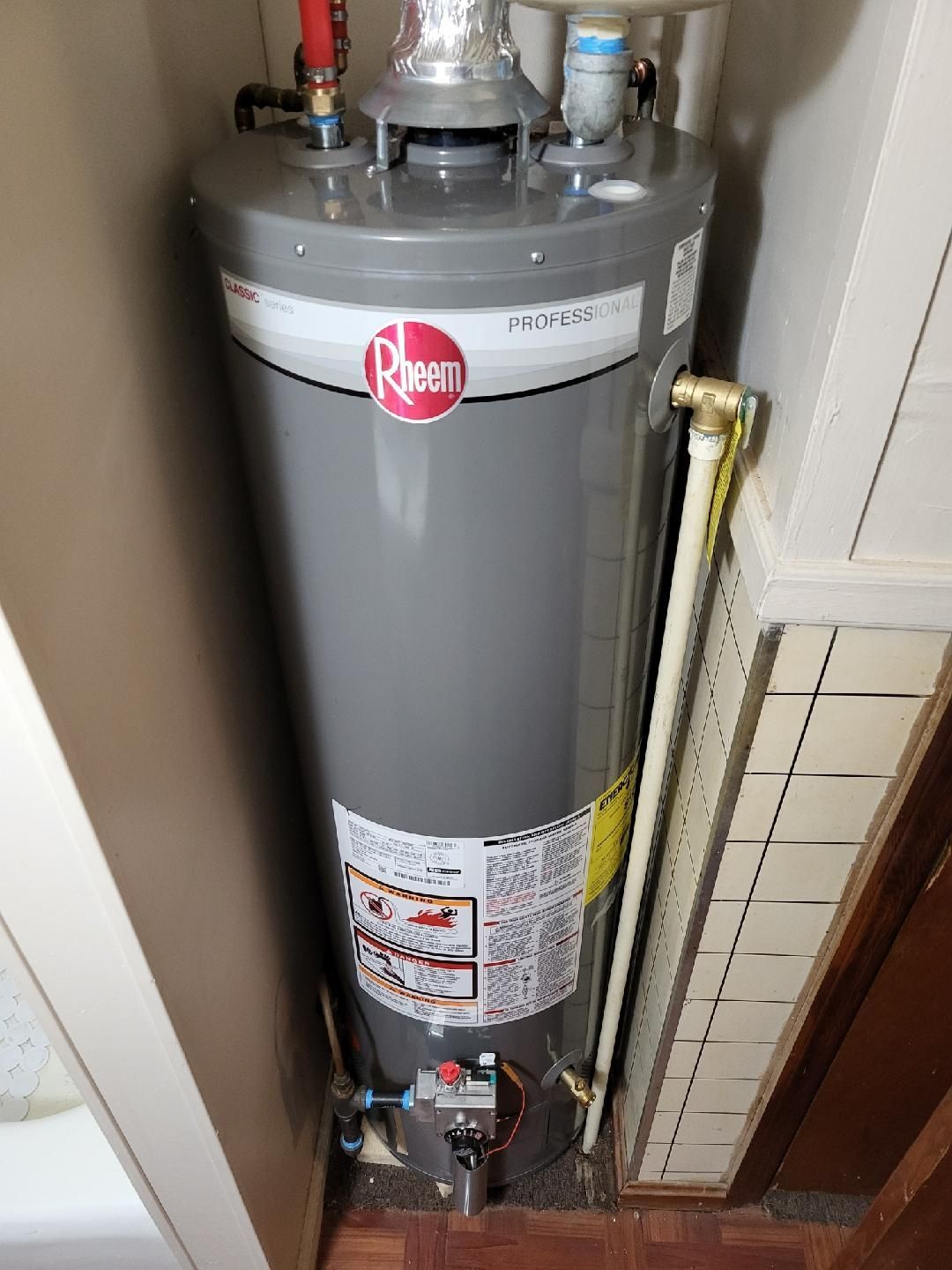 Gray Rheem water heater in a corner.