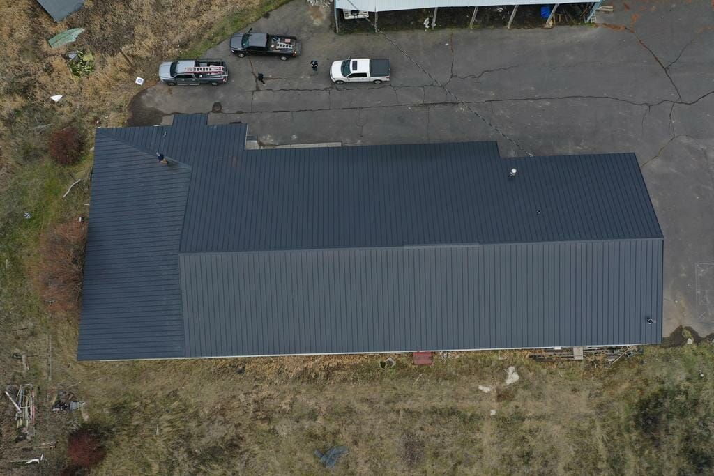 An aerial view of a large building with a black roof.