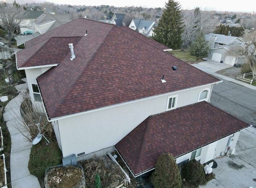 An aerial view of a large white house with a red roof.